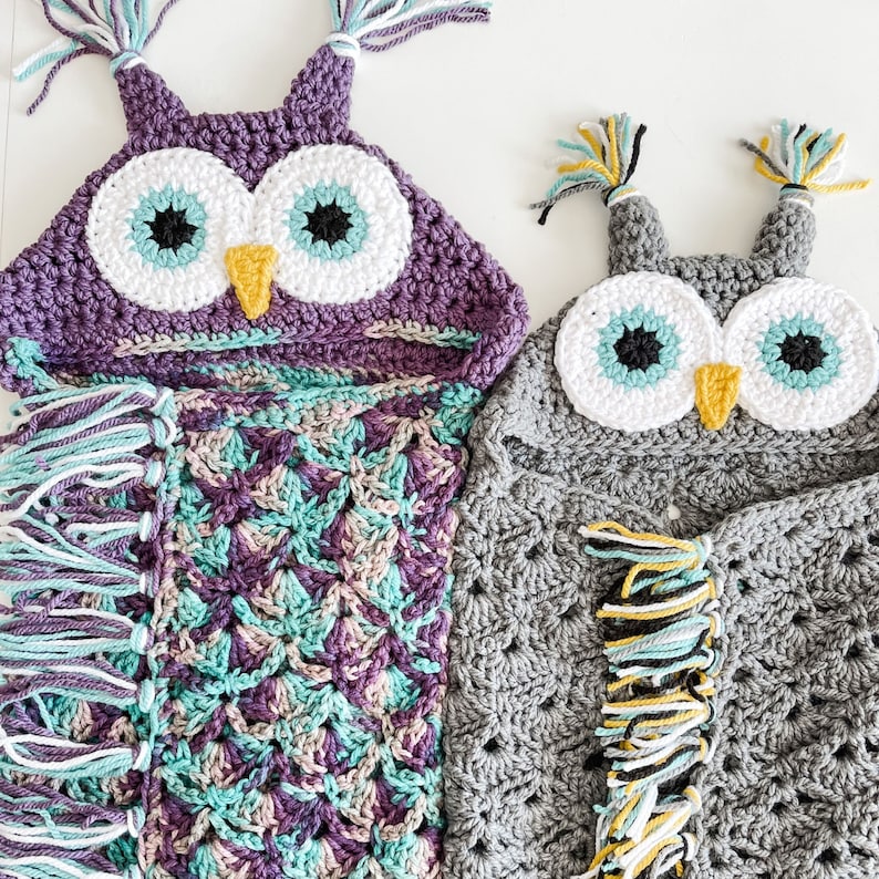 May include: Two crocheted owl baby blankets with purple and teal, and gray and white color schemes. Both blankets have fringe trim and owl faces with large eyes.