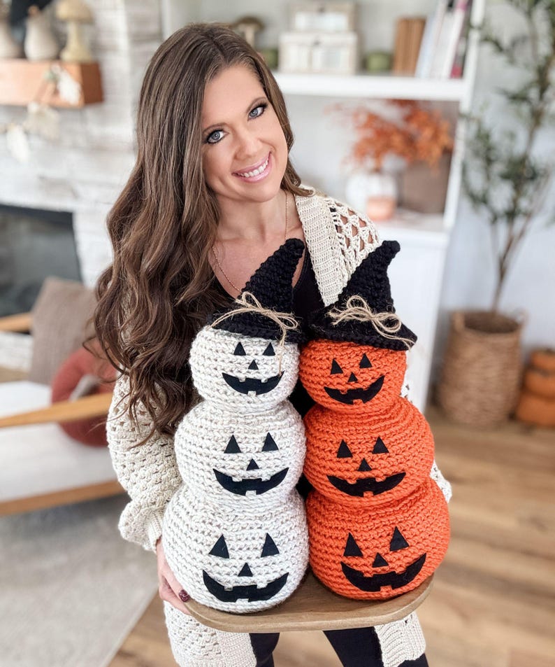 Orange and white stacked crochet jack-o-lanterns wearing black witch hats
