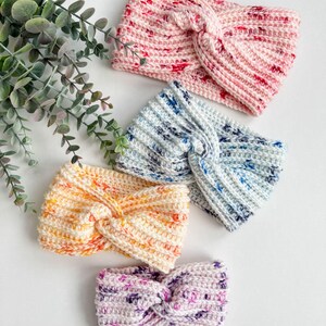May include: Four crocheted headbands in different colors and patterns. The headbands are made with a twisted knot design. The colors are pink, blue, yellow, and purple.