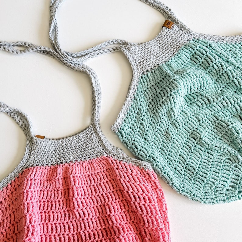 May include: Two crocheted tote bags, one in pink and gray and the other in green and gray. The bags have a simple, textured design.