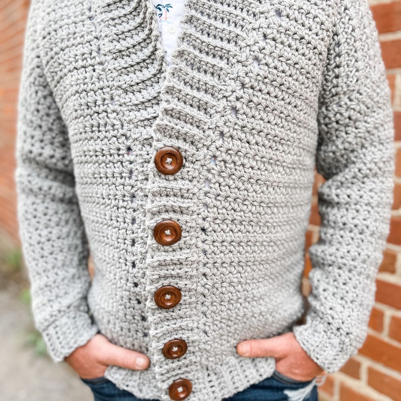 May include: A grey crocheted cardigan with a shawl collar and wooden buttons.