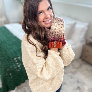 Peut inclure: Mitaines crochet&eacute;es &agrave; la main dans un d&eacute;grad&eacute; de cr&egrave;me, marron, bordeaux et orange. Les mitaines ont un poignet c&ocirc;tel&eacute; et une petite &eacute;tiquette en cuir. Les mitaines sont con&ccedil;ues pour la chaleur et le style.