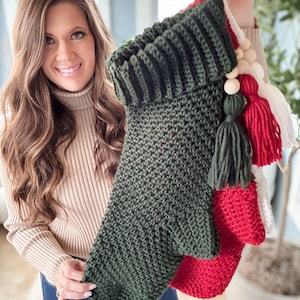 May include: Handmade Christmas stockings in green, red, and white. The green stocking has a textured knit pattern and a matching tassel. The red and white stockings have tassels and wooden bead accents. Festive holiday decor.