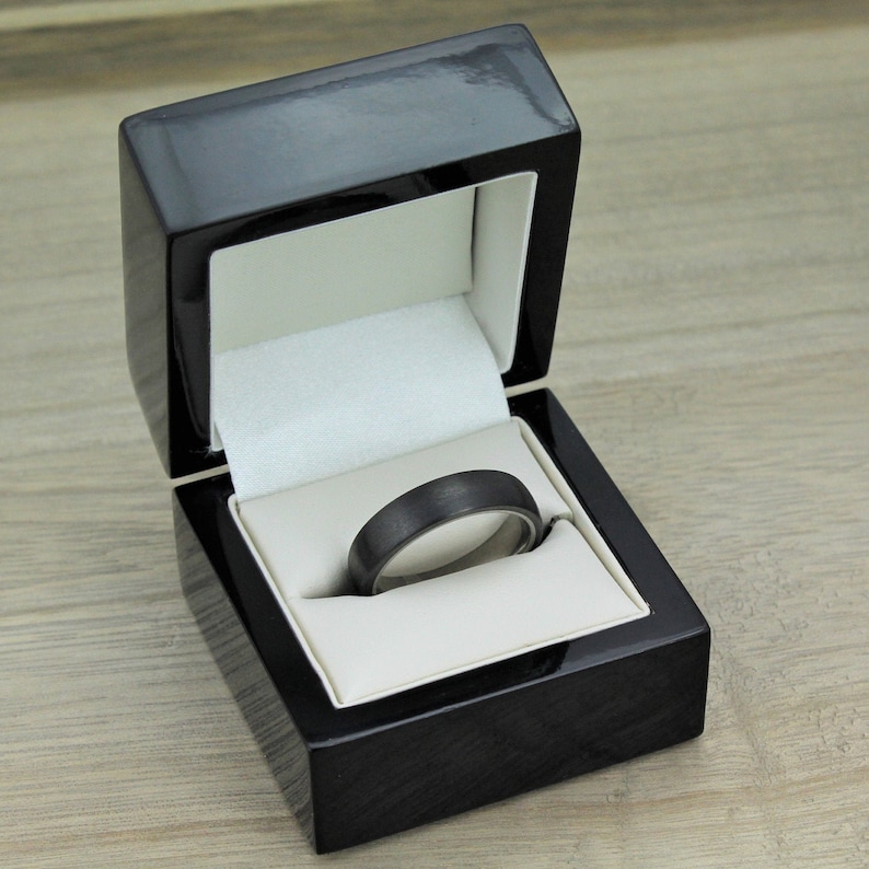 mens black wedding ring band in titanium and carbon fibre. matt/brushed dome shape, Flat court with a comfort fit inside the 10mm wide ring is inlayed with hand wound carbon fiber