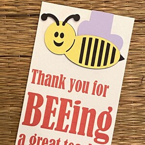 May include: A white card with a yellow and black bee illustration and the text "Thank you for BEEing a great teacher".