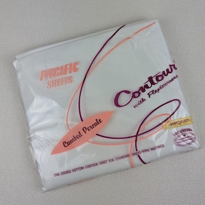 May include: A white package with pink and purple text that reads "Pacific Sheets Contour with Flexicorners" and "Combed Percale". The package also includes the text "One double bottom contour sheet for standard inner spring mattress" and "Sanforized Pre-Shrunk".