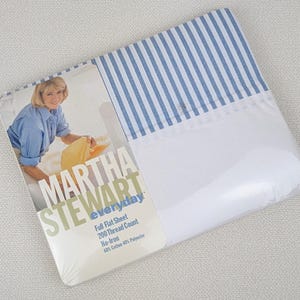 May include: A white and blue striped flat sheet packaged in plastic with a Martha Stewart Everyday label. The label says "Full Flat Sheet, 200 Thread Count, No-Iron, 60% Cotton 40% Polyester."