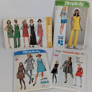 May include: A collection of vintage Simplicity sewing pattern envelopes. The patterns feature illustrations of women in various 1970s fashions, including dresses, jumpsuits, and pantsuits. The envelopes are in various colors, with text and pricing visible.