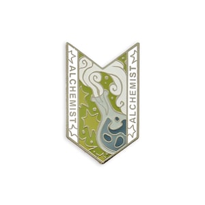 May include: A silver-colored enamel pin in a shield shape with the word "ALCHEMIST" on both sides. The pin features a flask with smoke, set against a green and yellow background.