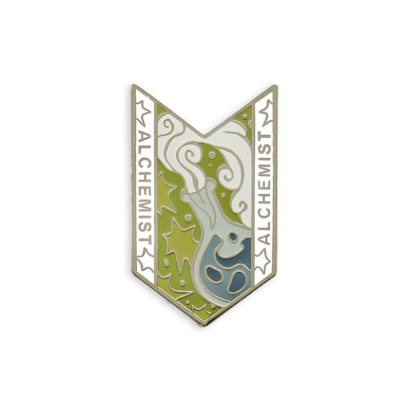 May include: A silver-colored enamel pin in a shield shape with the word "ALCHEMIST" on both sides. The pin features a flask with smoke, set against a green and yellow background.