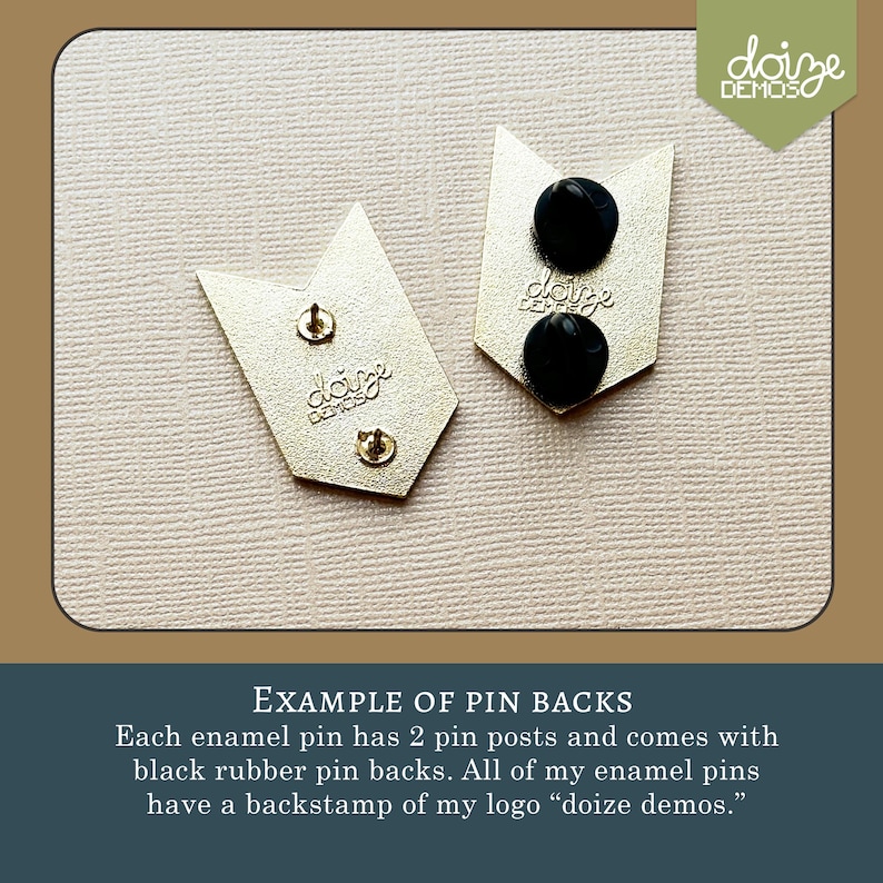 May include: Two gold-colored enamel pin backs with black rubber pin backs. Each pin has two posts. The pins are shaped like arrows. The text "doize demos" is stamped on the back of each pin.