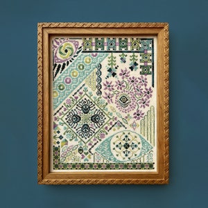 May include: A framed cross-stitch embroidery with a geometric pattern in shades of green, blue, and purple. The design features various shapes and floral motifs.
