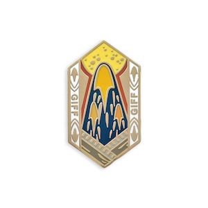 May include: A gold-colored enamel pin with a geometric design. The pin features a central design with yellow, blue, and orange shapes, and the word "GIFF" on either side. The top section has yellow dots.
