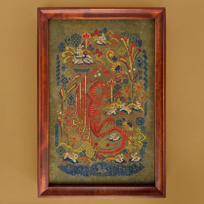 May include: Framed cross-stitch artwork featuring a red dragon design with floral and animal motifs in shades of blue, yellow, and green. The artwork is displayed in a dark brown wooden frame, creating a classic and decorative piece.