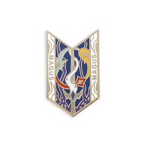 Puede incluir: Pin de esmalte de color dorado con un diseño morado, azul, blanco, rojo y amarillo. El pin presenta una espada estilizada y la palabra "MAGUS" a cada lado.