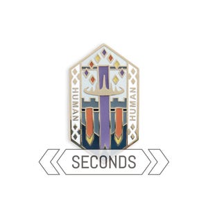 May include: A gold-colored enamel pin with a geometric design featuring a sword, banners, and the word "HUMAN" on either side. The pin has a white background with orange, yellow, and purple accents. The word "SECONDS" is below the pin.