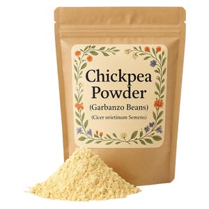 May include: A brown paper bag with a floral design label that reads "Chickpea Powder (Garbanzo Beans) (Cicer arietinum Semens)". A pile of yellow chickpea powder is in front of the bag.