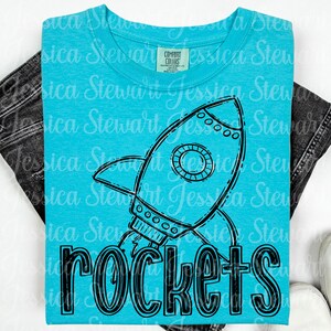 May include: A turquoise t-shirt featuring a black and white rocket ship graphic with the word "rockets" in bold letters. The shirt is made of a soft material and is suitable for casual wear.