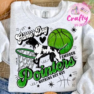 May include: A light gray sweatshirt with a basketball-themed graphic. The design features a black and white dog, a green basketball, and the words "Game Day" and "Pointers" in a sporty font. The phrase "Nothing But Net" is also included.