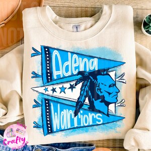 May include: A cream colored sweatshirt with a blue and white design featuring the words "Adena Warriors" and a Native American warrior head. The design is in a vintage style with a watercolor effect.