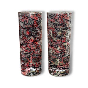 May include: Two tall, clear drinking glasses with a vibrant abstract design. The glasses feature a pattern of intertwined black and red lines, with the word "ROSE" visible on the glass. The design covers the entire surface of the glasses.