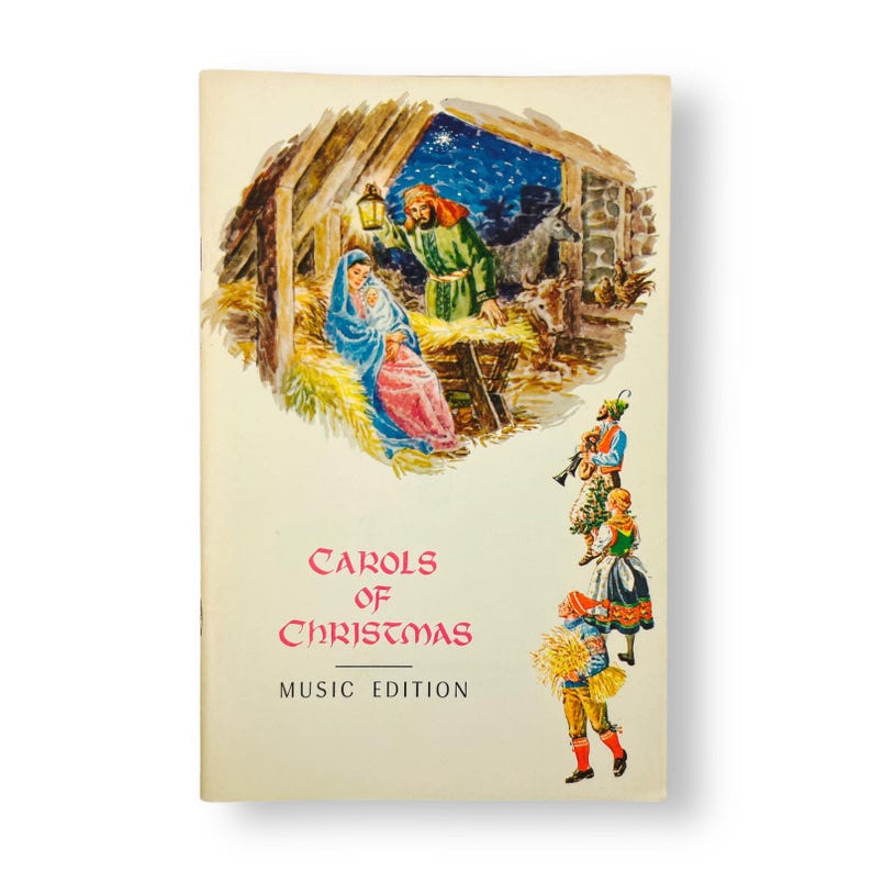 May include: A vintage 'Carols of Christmas' music edition book cover. The cover features a colorful illustration of the Nativity scene with Mary, Joseph, and baby Jesus in a stable. A man with a lantern and a group of carolers are also depicted. The text 'Carols of Christmas' and 'Music Edition' are in red and black.