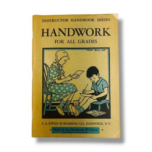 May include: A tan softcover book titled Instructor Handbook Series Handwork For All Grades by F. A. Owen Publishing Co. The cover features a black and teal illustration of two children working at desks, with the text Price of this Handbook, 50 Cents.