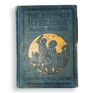 May include: A vintage blue hardcover book titled The Pathway to Reading First Reader by Coleman, Uhl, and Hosic. The front cover features a circular illustration of two children walking in a field with a golden sky background and dark blue text.
