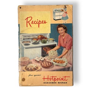 May include: Vintage cookbook cover with the word "Recipes" in red script. The cover features an illustration of a woman with baked goods and a Hotpoint electric range. The cover is beige and has a hole at the top.