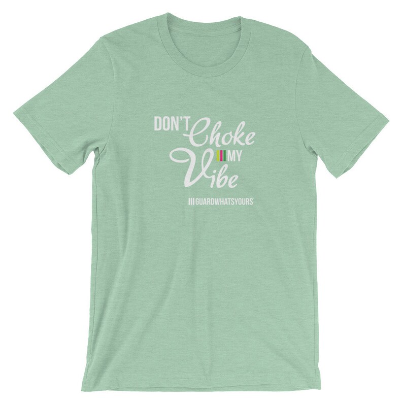 May include: A light green t-shirt with the text "Don't Choke My Vibe" in white. The text is in a stylized font with a colorful flag graphic. The text "III GUARDWHATSYOURS" is below the main text.