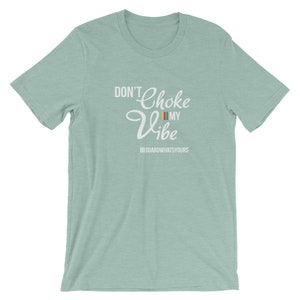 May include: A light blue t-shirt with the text "Don't Choke My Vibe" in white lettering. The text is in a cursive font and includes a small rainbow flag graphic. The text "III GUARDWHATSYOURS" is also included in white lettering.