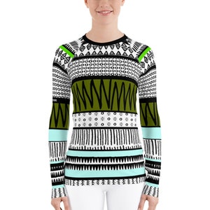 May include: A long-sleeved shirt with a geometric pattern in black, white, green, and blue. The pattern is made up of triangles, circles, and lines.