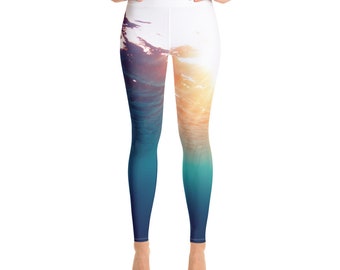 May include: High-waisted leggings with a vibrant ocean-themed design. The leggings feature a gradient of colors, transitioning from deep blue at the ankles to a bright, sunlit effect at the waist. The design evokes an underwater scene.