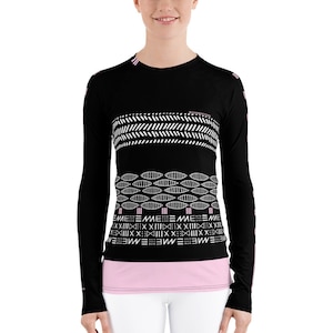 May include: Black long-sleeve shirt with a geometric pattern in white and pink. The pattern features a series of repeating shapes, including circles, triangles, and lines.