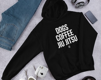 May include: Black hooded sweatshirt with white text that reads "Dogs Coffee Jiu Jitsu".