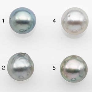 May include: Nine round, iridescent pearls in various shades of gray and blue. The pearls are numbered 1 through 9.
