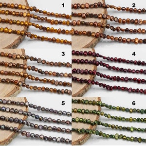 Op de afbeelding: Zes strengen zoetwaterparels in verschillende kleuren, waaronder goud, bordeauxrood, grijs en groen. De parels zijn allemaal onregelmatig van vorm en hebben een licht iriserende glans.