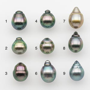 May include: Nine iridescent, teardrop-shaped pearls are displayed against a white background. Each pearl has a unique shape and color, ranging from dark green to gold and silver. The pearls are numbered 1 through 9.