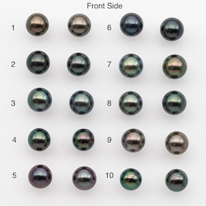 Puede incluir: Una colección de diez perlas redondas y brillantes en varios tonos de negro, verde y bronce. Las perlas están dispuestas en filas, mostrando su iridiscencia natural y sutiles variaciones de color. La imagen está etiquetada como "Front Side".