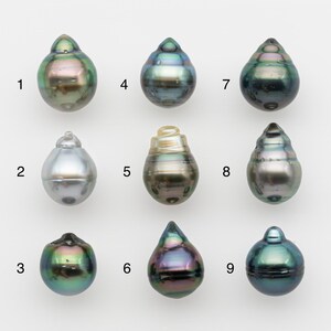 May include: Nine iridescent, teardrop-shaped pearls in various colors, including green, silver, and purple. Each pearl has a unique shape and surface texture, with a smooth, polished appearance. The pearls are arranged against a white background.