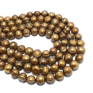 May include: A strand of golden brown freshwater pearls. The pearls are round and have a smooth, iridescent finish.