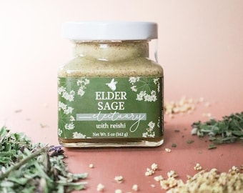 Miele medicinale per il supporto immunitario, cura delle vie respiratorie, integratore biologico di fiori di sambuco e funghi Reishi, ideale come erboristeria casalinga o regalo in stile cottagecore.