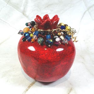 Granada mediana con esmalte brillante color rubí y cuentas multicolores