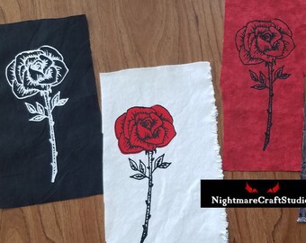 Aplique de tecido serigrafado com contorno de rosa ou rosa vermelha preenchida.