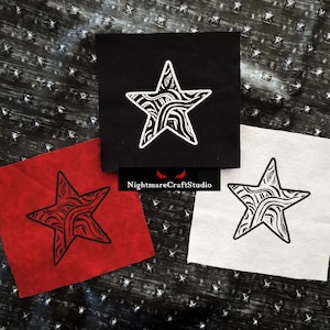 Pode incluir: Três patches de tecido com um design de estrela preto e branco. A estrela é preenchida com um padrão de redemoinho. Os patches estão sobre um fundo preto e branco. Os patches são vermelho, preto e branco.