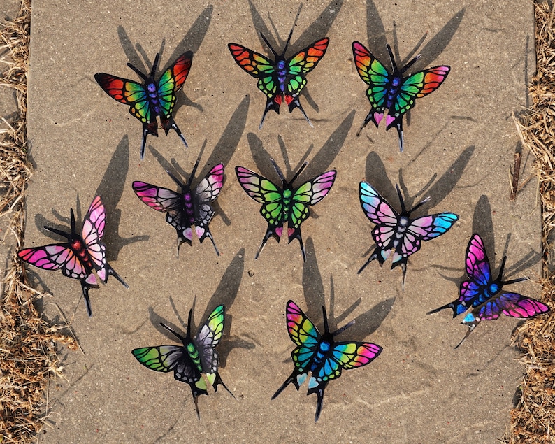 May include: Assortment of colorful butterfly decorations with iridescent wings. The butterflies are made of metal and have a 3D effect.