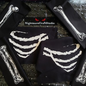 May include: Five black fabric squares with white skeleton bone designs. The designs include a rib cage, a long bone, and a pair of bones. The text "NightmareCraftStudio" is printed on one of the squares.