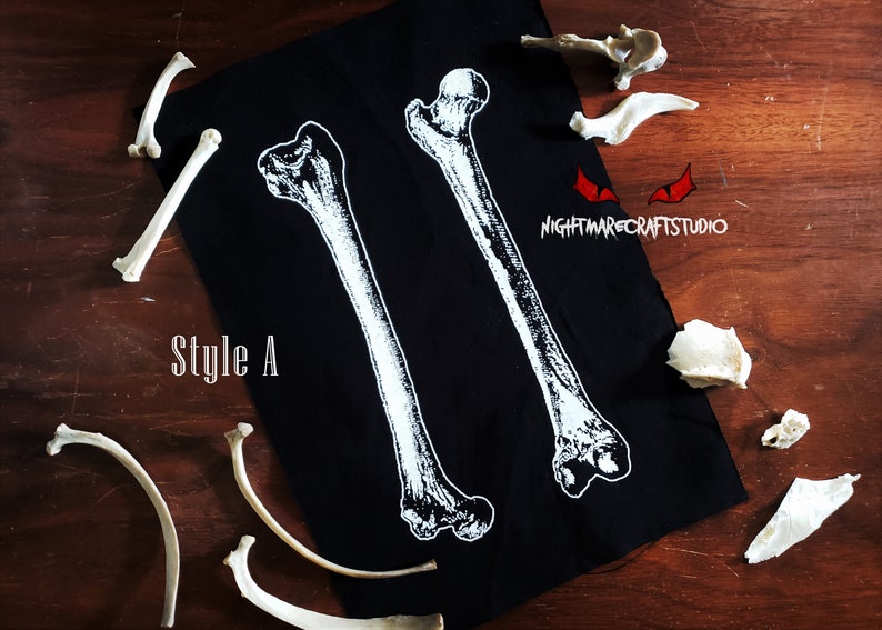 May include: Black fabric with two white bone images printed on it. The text "Style A" is printed in white on the fabric. The fabric is surrounded by several white bones.