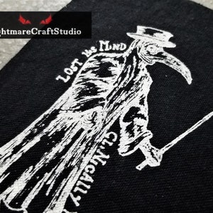 May include: Black and white embroidered patch featuring a plague doctor with a long beak and a hat. The text "Lost in the Mind" is written above the doctor.
