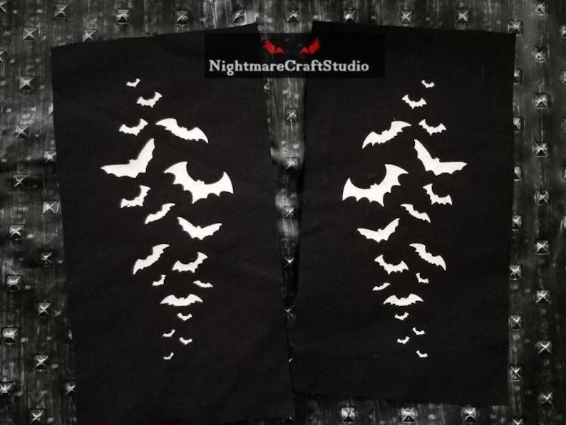May include: Two black fabric patches with white silhouettes of bats arranged in a vertical line. The text "NightmareCraftStudio" is printed in white on the top right patch.